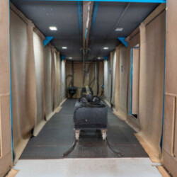 Interior of an industrial sandblasting booth with equipment for surface preparation