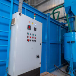 Industrial control panel and machinery setup for material processing.