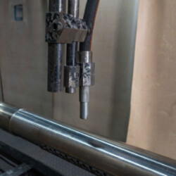 Close-up of industrial equipment preparing to machine a cylindrical metal workpiece