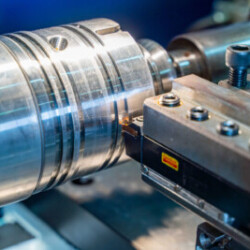 Close-up of a metal workpiece being machined on a lathe with precision tools
