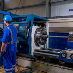 Technician operating a CNC lathe machine in an industrial workshop